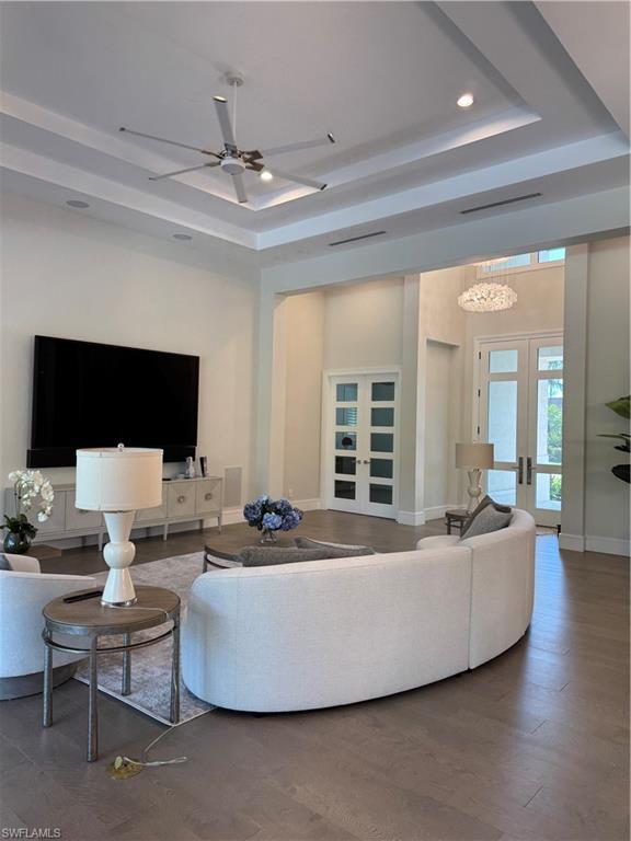 Image 4: Living room with french doors, baseboards, a raised ceiling, and a ceiling fan