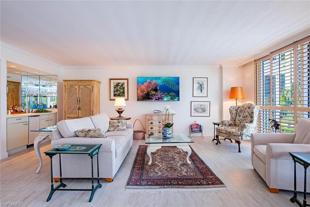 Image 1: Spacious living area featuring light-toned tile flooring throughout