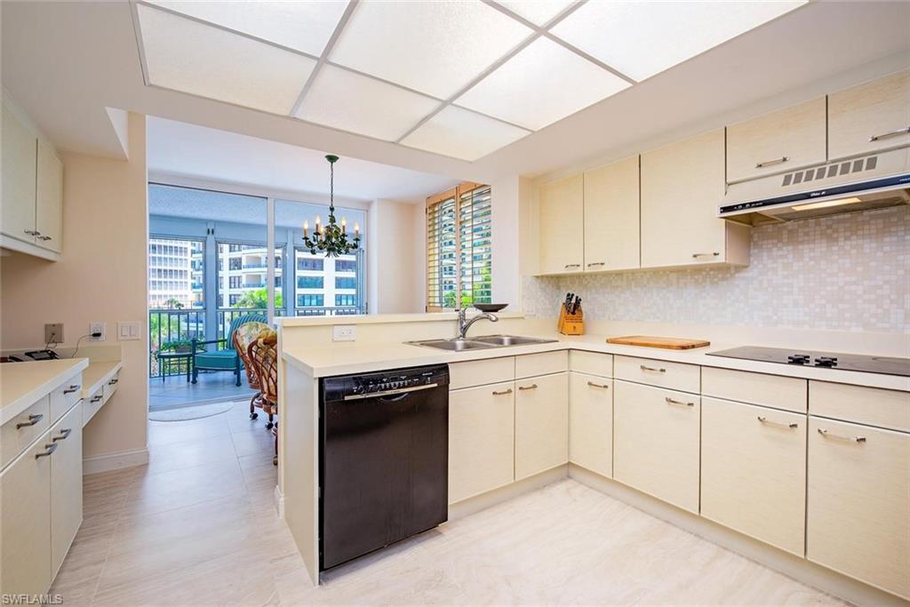 Image 4: L-shaped kitchen featuring cream cabinetry, a built-in black dishwasher, and a black cooktop