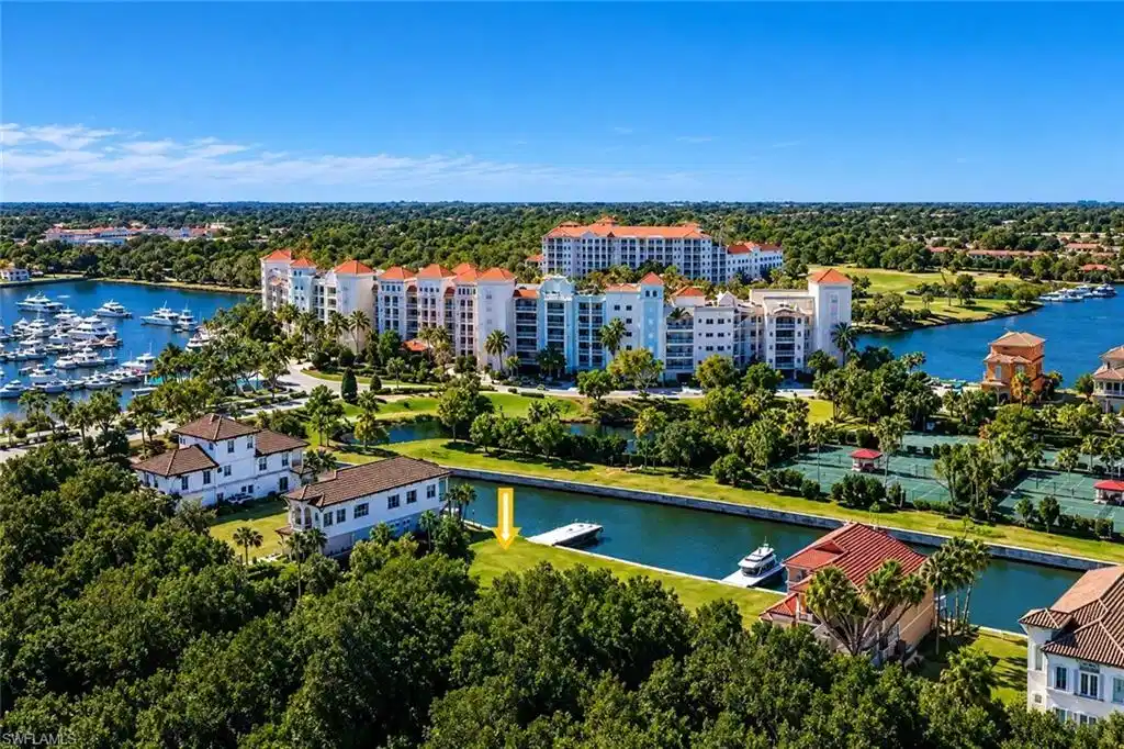 Image 1: Waterfront property with boat dock, surrounded by mature trees and manicured landscaping