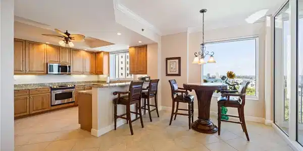Image 4: Kitchen with a breakfast bar, hanging light fixtures, a peninsula, ornamental molding, and stainless steel appliances