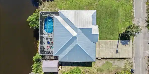 Image 2: Property with a screened pool, metal roof, and waterside location