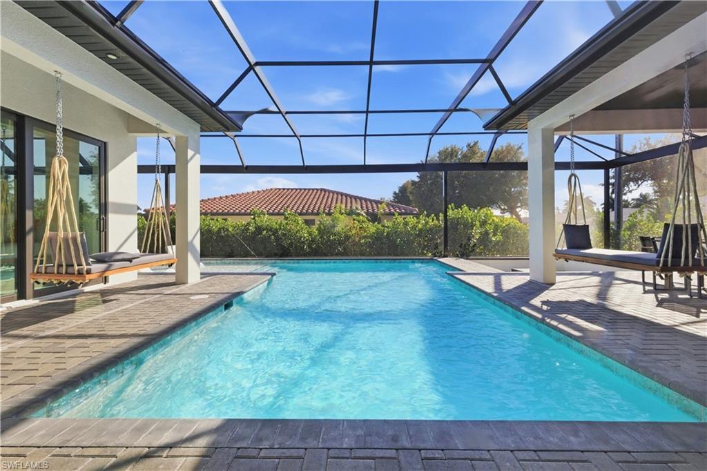 Image 2: Outdoor pool featuring a sunroom, a patio, and a lanai