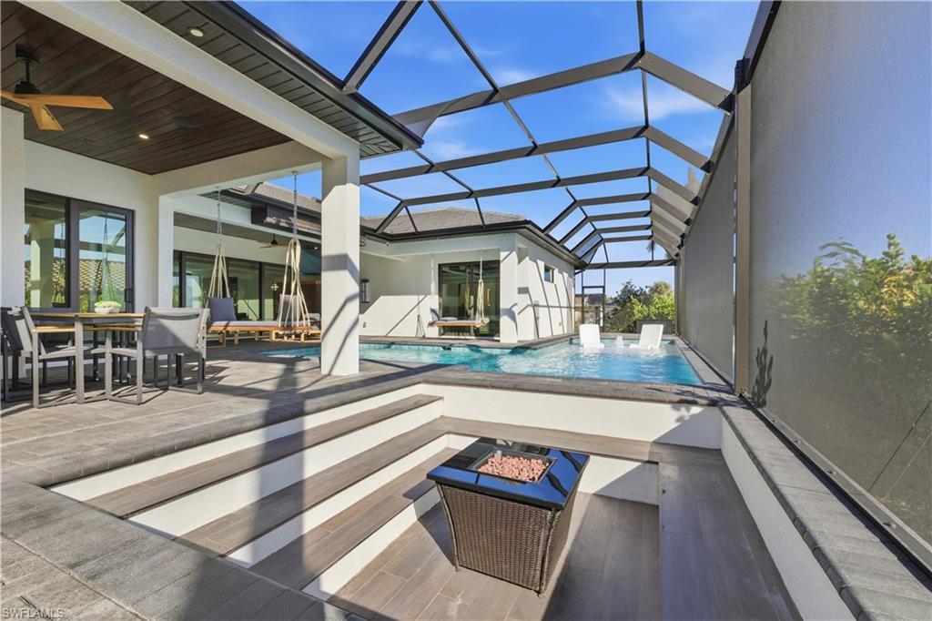 Image 4: Outdoor pool featuring a patio, a sunroom, outdoor dining area, and a lanai