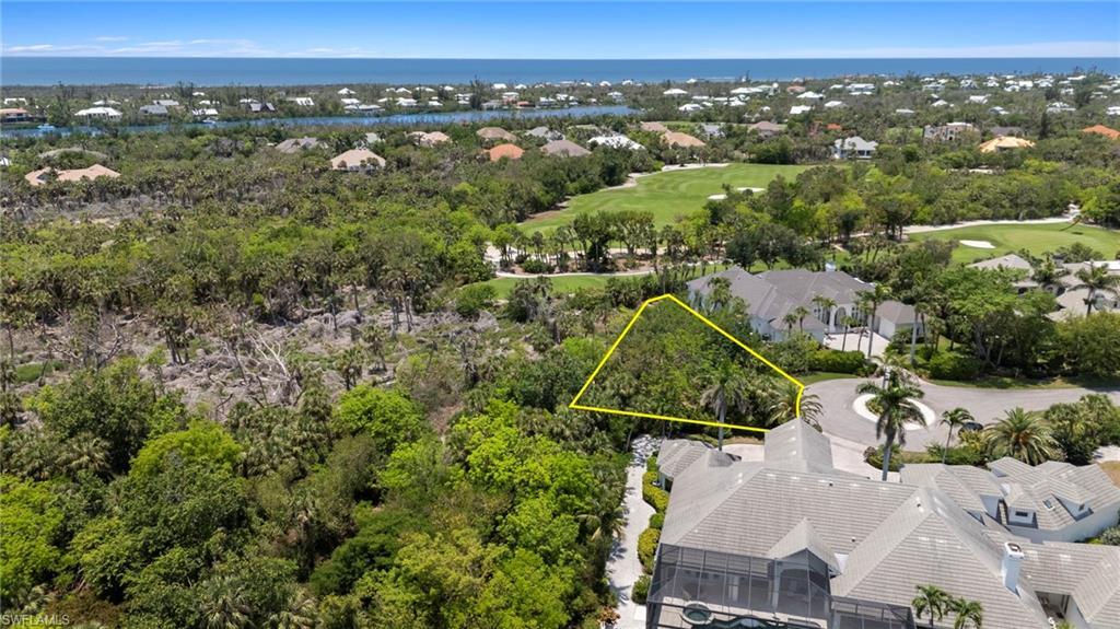 Image 3: Aerial perspective of suburban area with a golf club, property parcel outlined, a tree filled landscape, and a large body of water