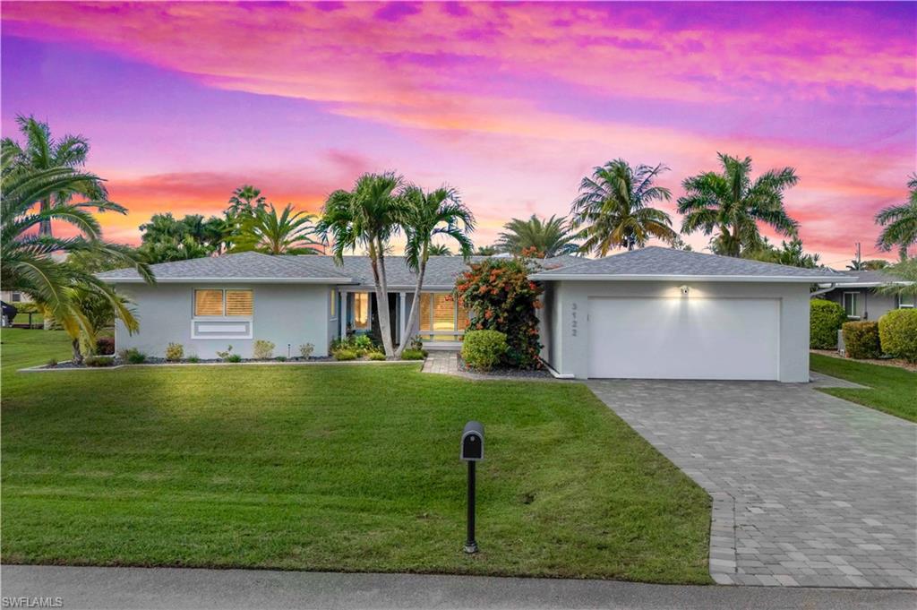 Image 2: Dramatic sunset over the backyard as seen from the beautifully landscaped front of the home.