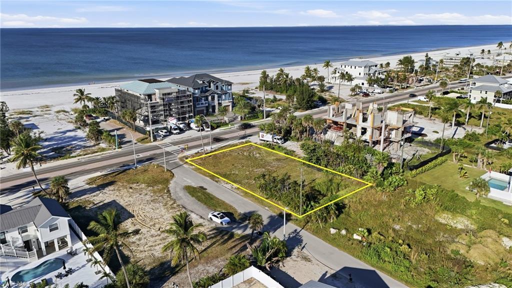 Image 2: Aerial overview of property's location with property parcel outlined and unending shoreline - Virtually Edited Image