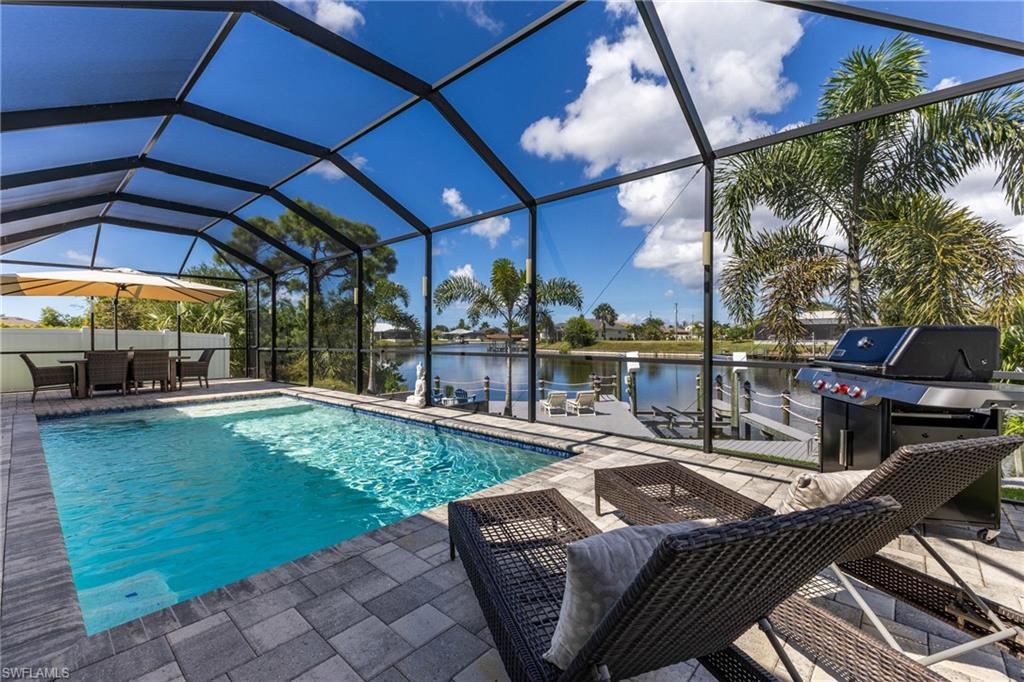 Image 3: Swimming pool with a water view, glass enclosure, a sunroom, and a patio area