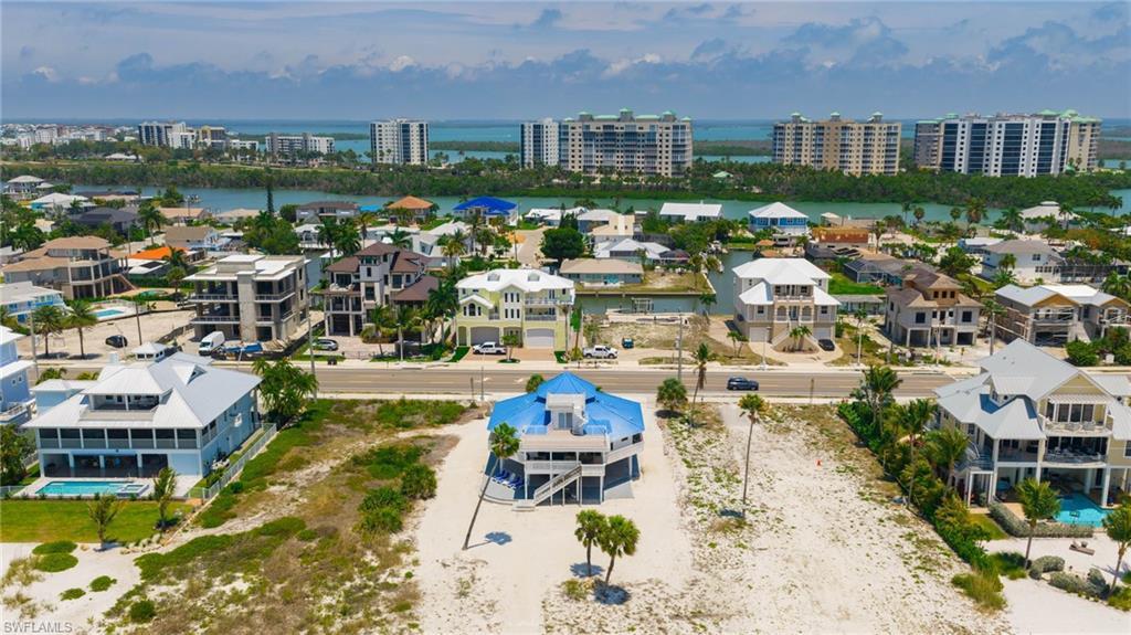 Image 4: Aerial perspective showcasing a coastal community with numerous multi-story residences - Virtually Edited Image