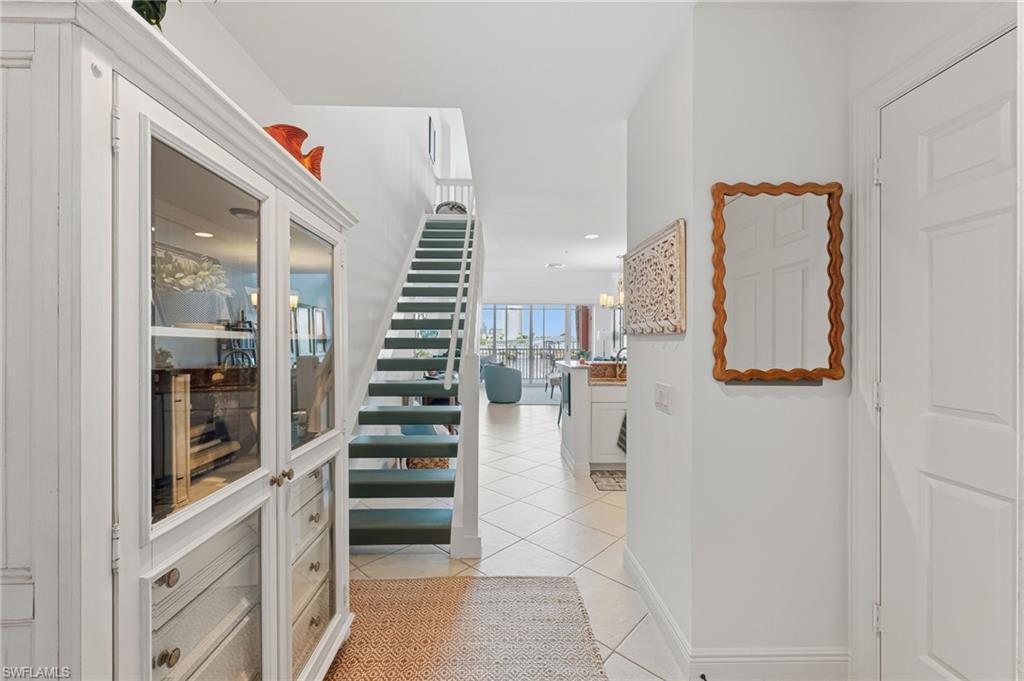 Image 4: Entryway featuring a white cabinet with glass doors and drawer storage