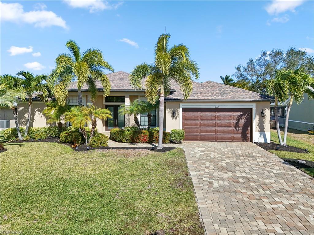 Image 1: Ranch-style house featuring a front yard and stucco siding