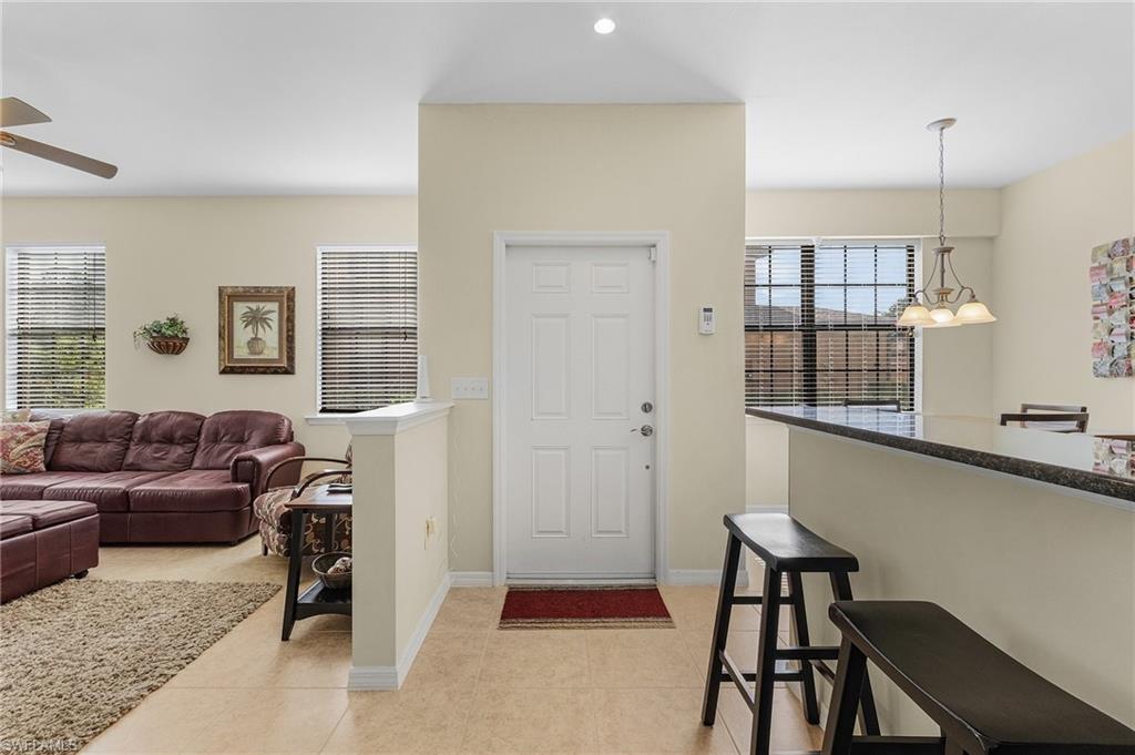 Image 3: Tiled foyer entrance with ceiling fan with notable chandelier