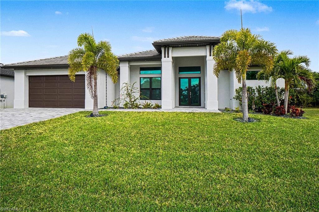 Image 3: Prairie-style home featuring french doors, decorative driveway, a front lawn, and stucco siding