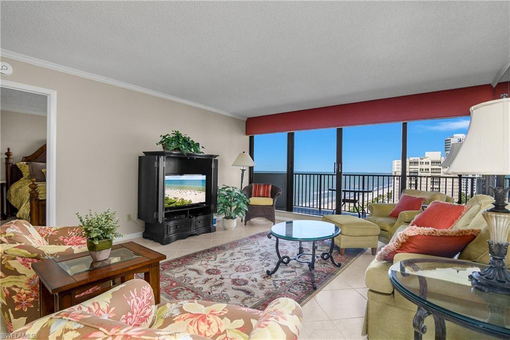 Image 2: Tiled living room with crown molding and a textured ceiling