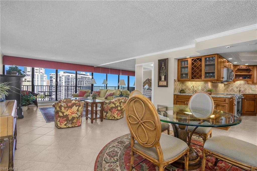 Image 4: Dining room featuring ornamental molding, a textured ceiling, light tile patterned floors, and a city view
