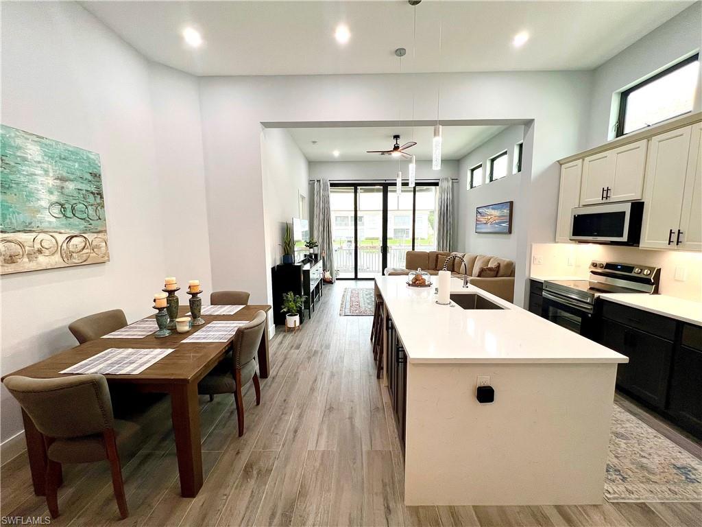 Image 4: Open-concept living space featuring high ceilings, wood-finish flooring, and recessed lighting