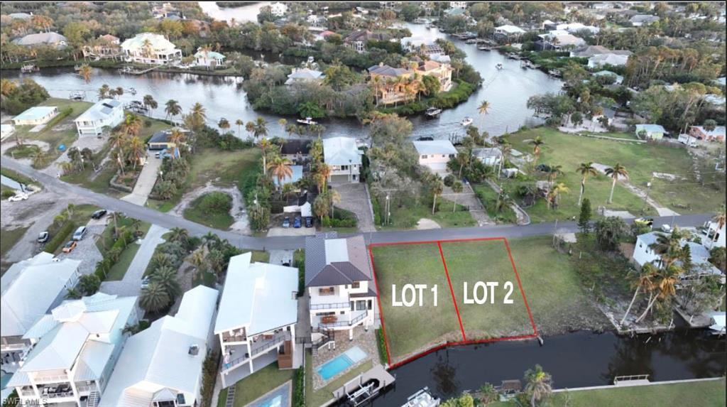 Image 3: Aerial view of residential area with a nearby body of water and property parcel outlined
