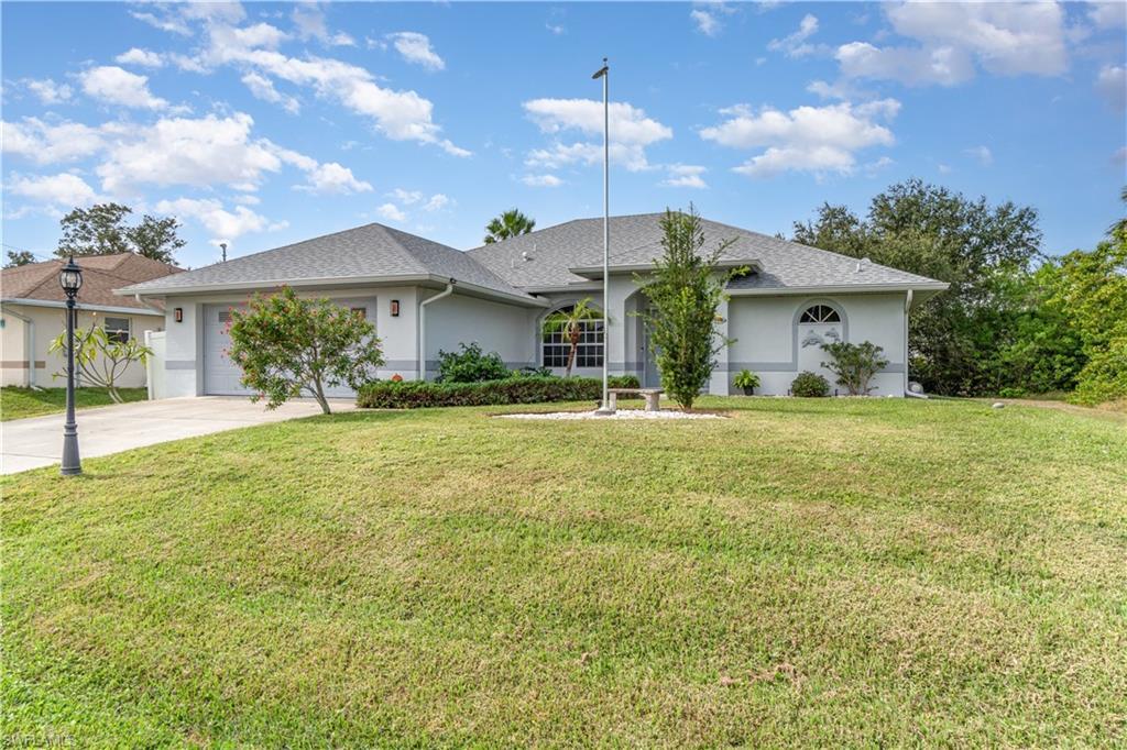 Image 1: Ranch-style house featuring stucco siding, a front lawn, concrete driveway, a garage, and roof with shingles