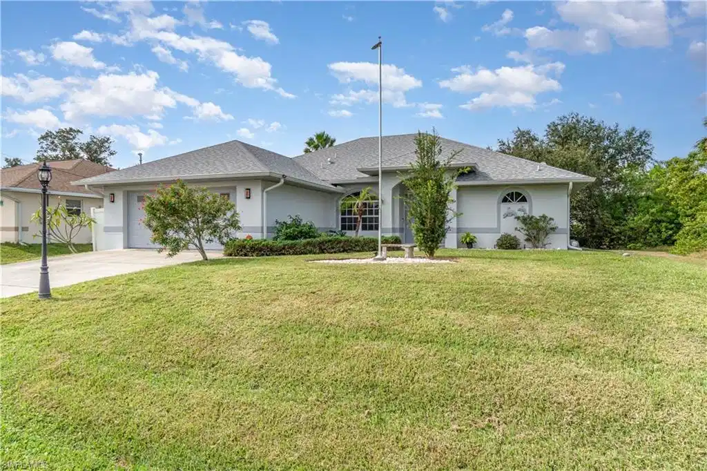 Image 1: Ranch-style house featuring stucco siding, a front lawn, concrete driveway, a garage, and roof with shingles