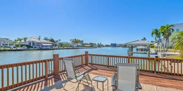 Image 2: Dock featuring boat lift and a deck with water view