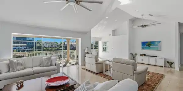 Image 4: Tiled living area featuring a ceiling fan and high vaulted ceiling