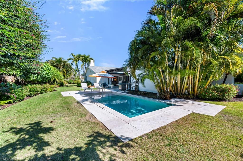 Image 3: Open Pool area surrounded with lush landscaping