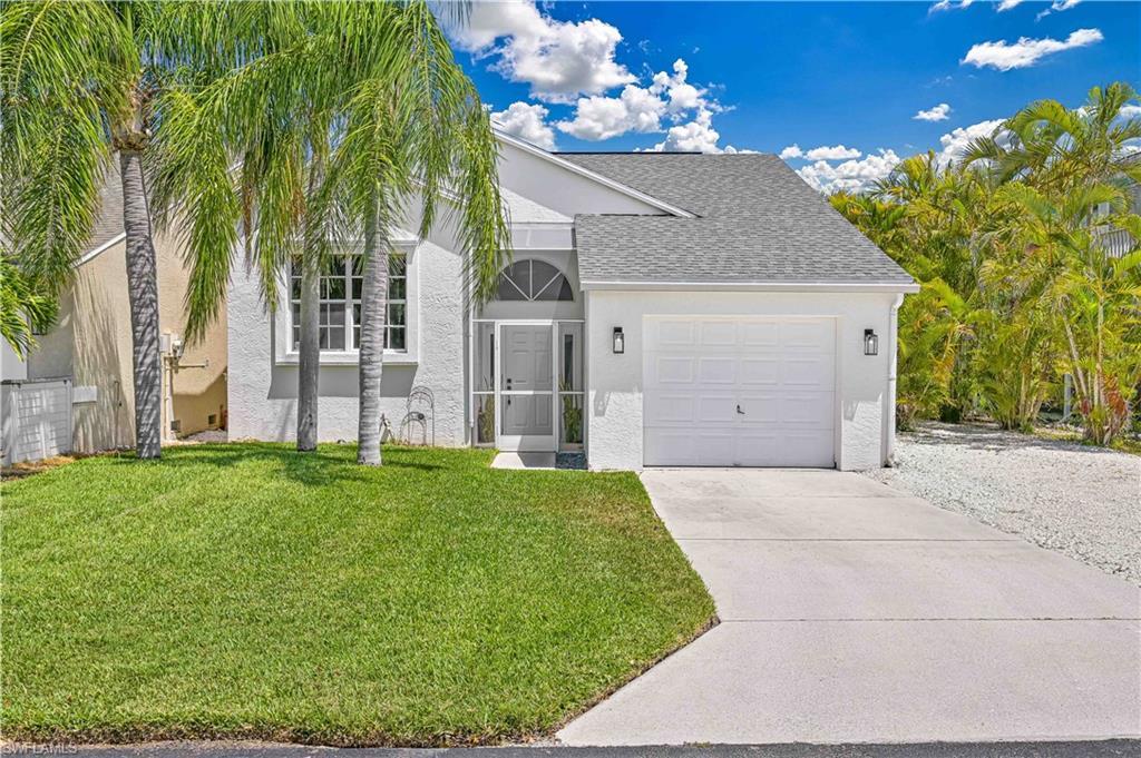 Image 1: View of front of property with stucco siding, concrete driveway, a front yard, and a garage