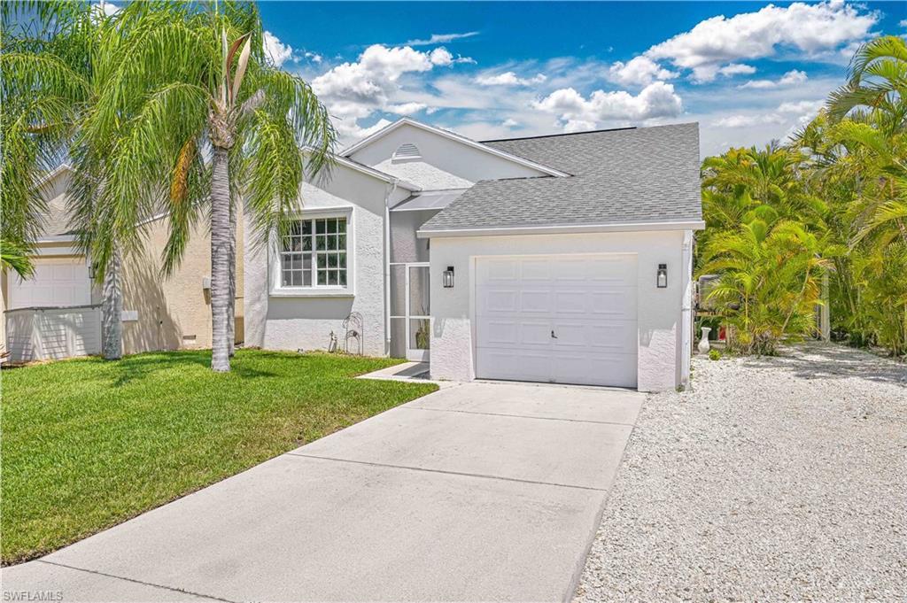 Image 2: View of front of house featuring roof with shingles, a front lawn, concrete driveway, an attached garage, and stucco siding