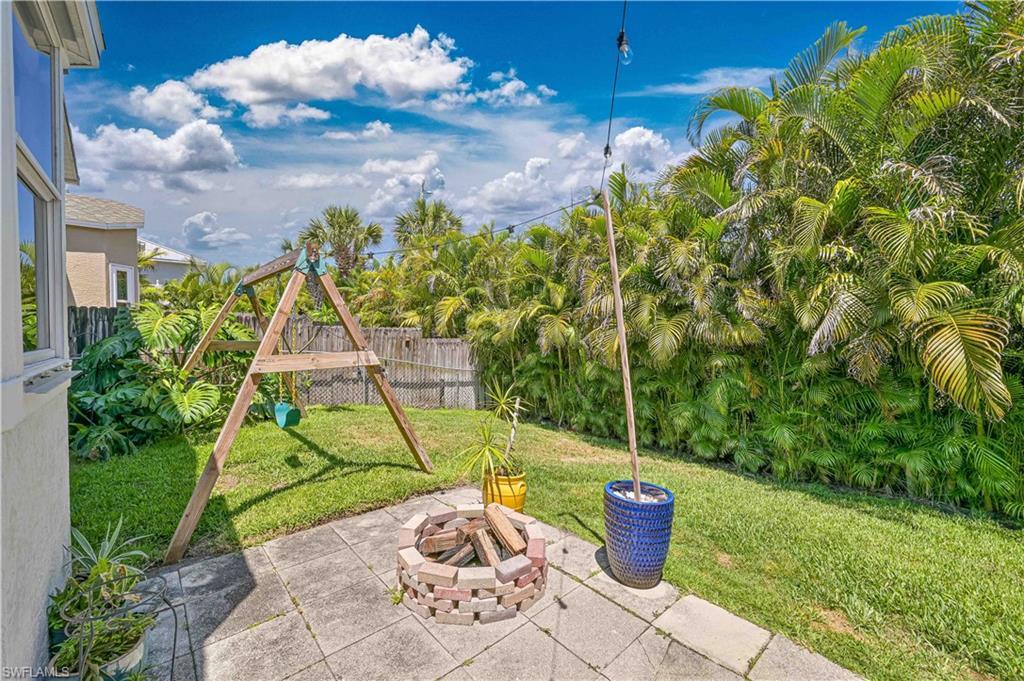 Image 4: View of patio / terrace featuring a playground, fence, and an outdoor fire pit