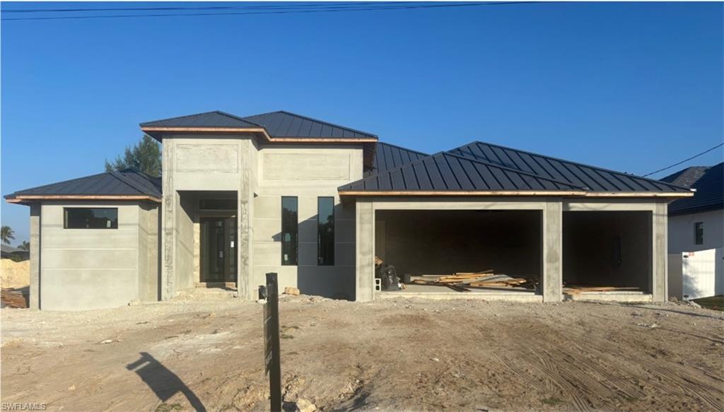Image 2: View of front of property with a metal roof, a standing seam roof, and a patio