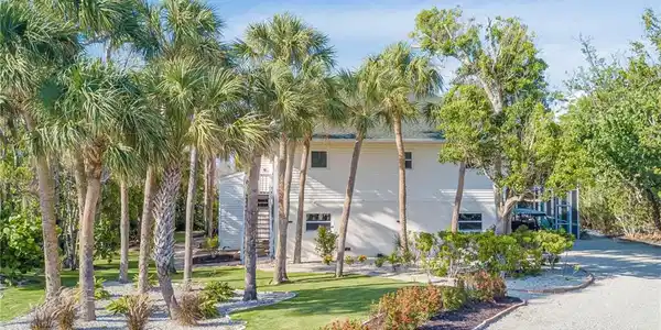 Image 2: NEW landscaping, NEW Impact windows, NEW stairs up to the 2nd level, plenty of space in the driveway to park and golf cart! 2+car garage, screened-in pool and patio area, bonus lower level, and so much more!