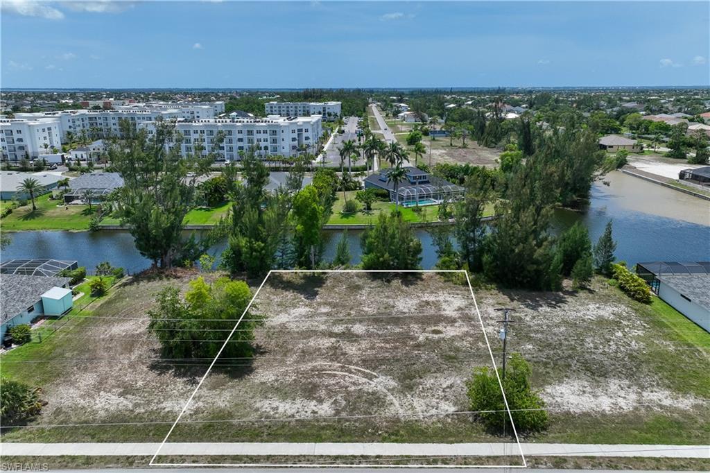 Image 1: Aerial overview of property's location featuring a nearby body of water and property boundaries highlighted