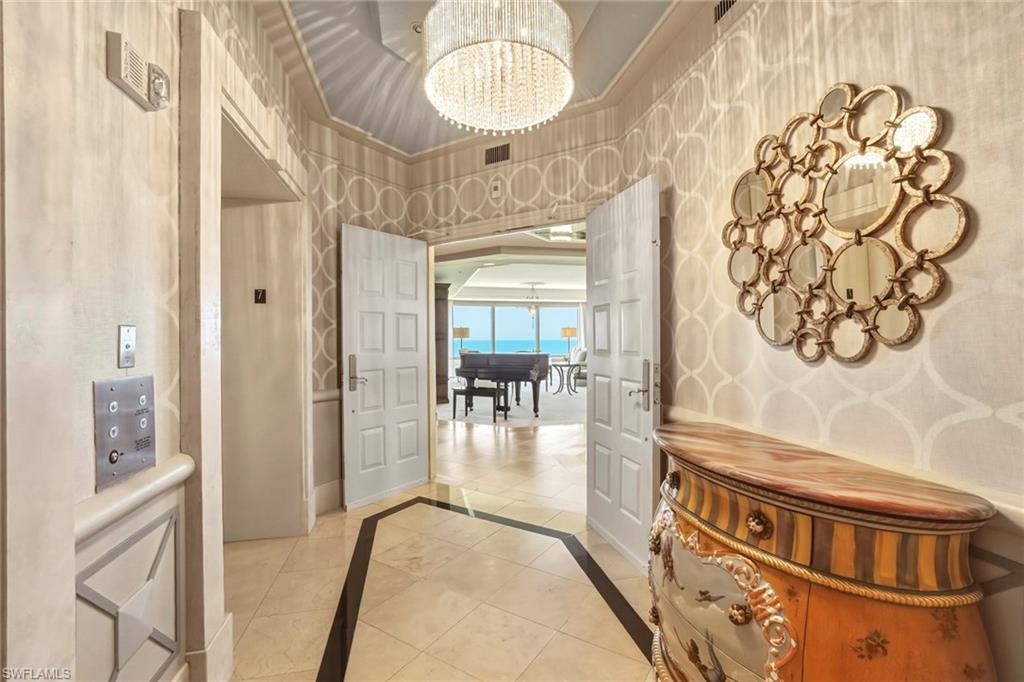 Image 2: Entrance foyer featuring hanging lights, inlaid floor details, and wallpapered walls
