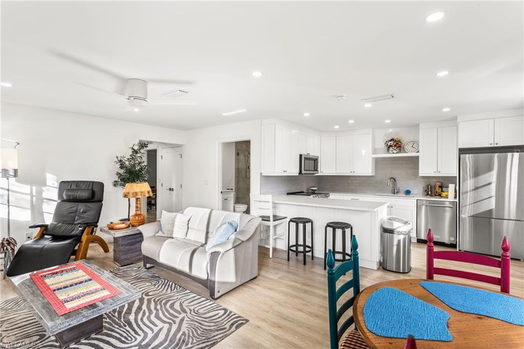 Image 4: Living area with light wood-style flooring and recessed lighting