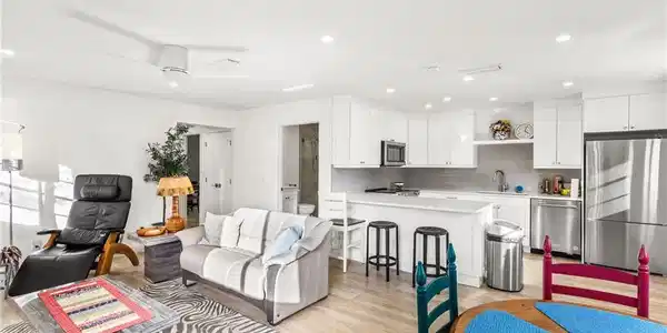 Image 4: Living area with light wood-style flooring and recessed lighting