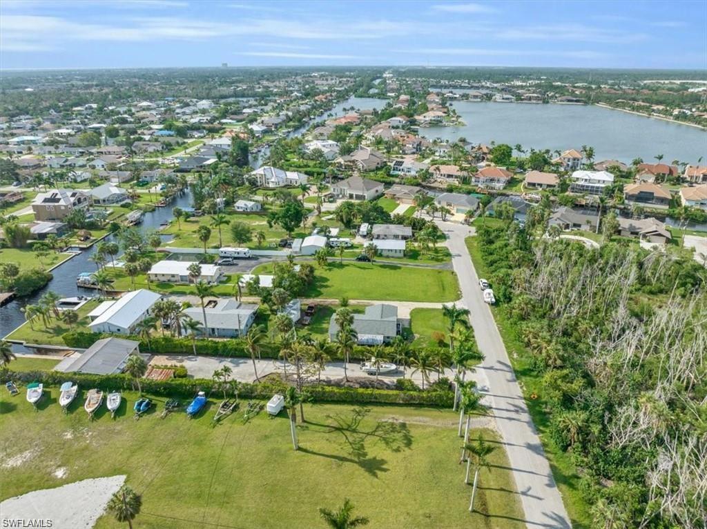 Image 3: Aerial view of residential area featuring a nearby body of water