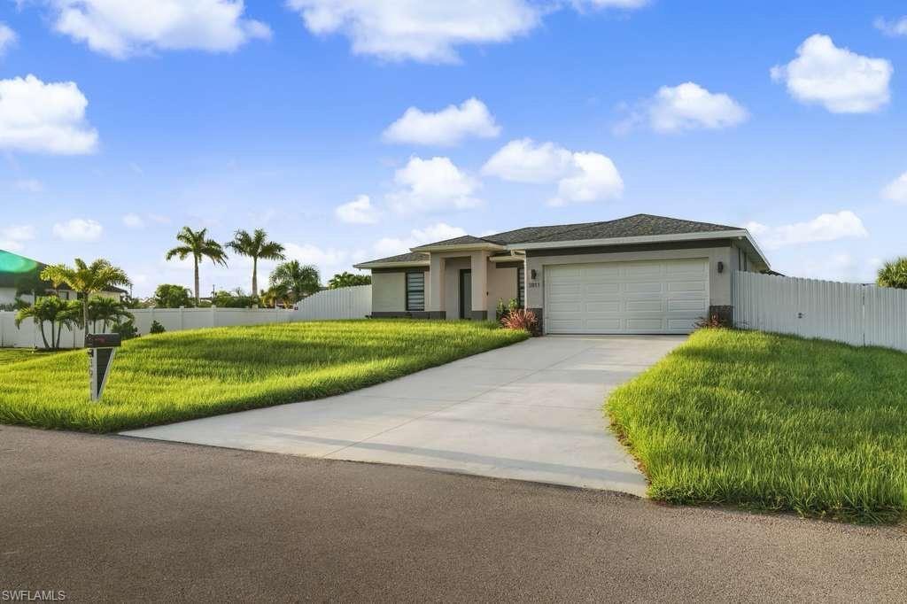 Image 2: Ranch-style house with stucco siding, driveway, and a garage