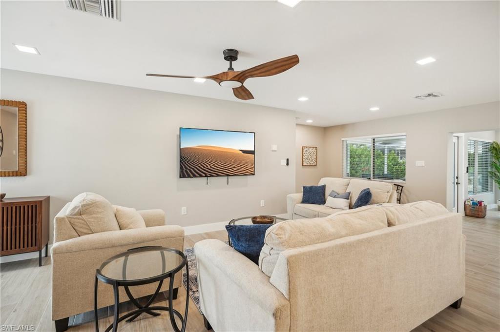 Image 2: Living room with light wood-type flooring and ceiling fan