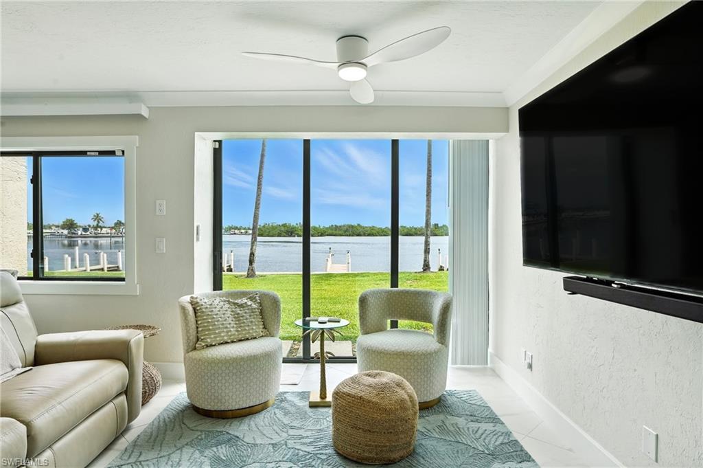 Image 2: Living area featuring ceiling fan, tile patterned floors, and a textured wall