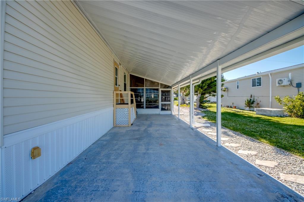 Image 3: The property features an extensive covered concrete patio, offering a screened-in area for added comfort
