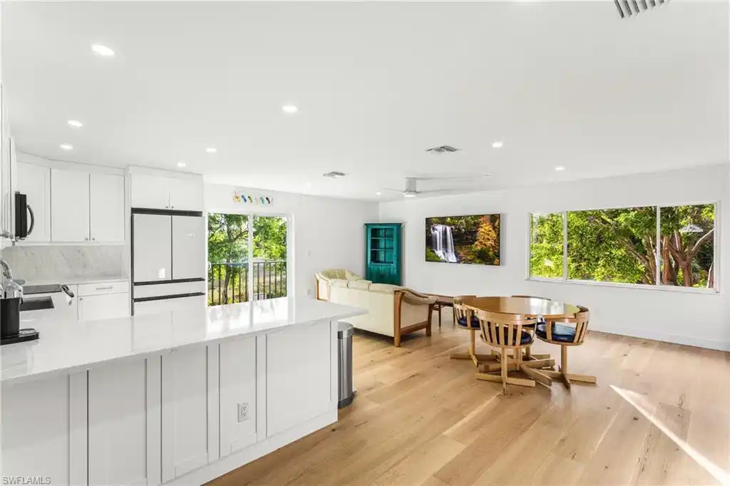 Image 1: Kitchen with white cabinets, light stone counters, a peninsula, freestanding refrigerator, and recessed lighting