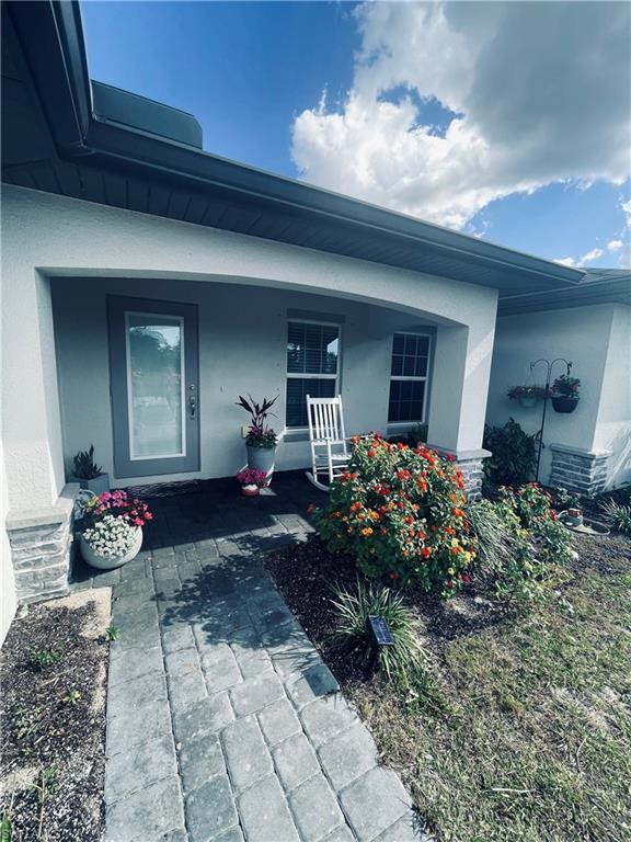 Image 3: Entrance to property with stucco siding and a porch