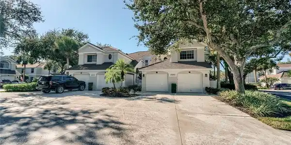 Image 2: Coach Home featuring driveway, stucco siding, an attached garage, and a tiled roof