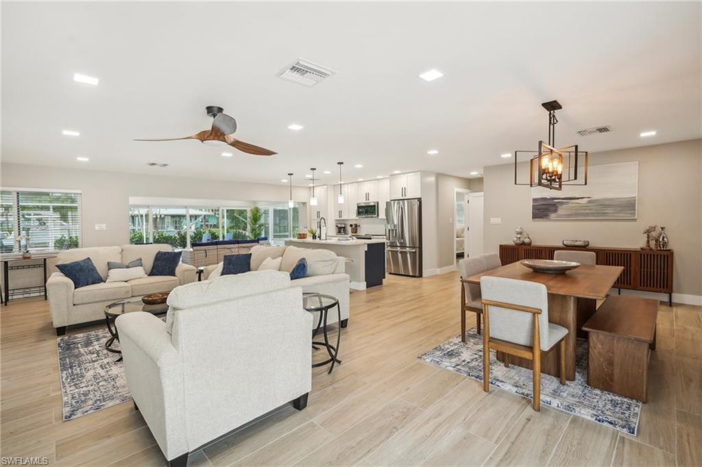 Image 3: Living room featuring light hardwood / wood-style flooring, sink, and ceiling fan with notable chandelier