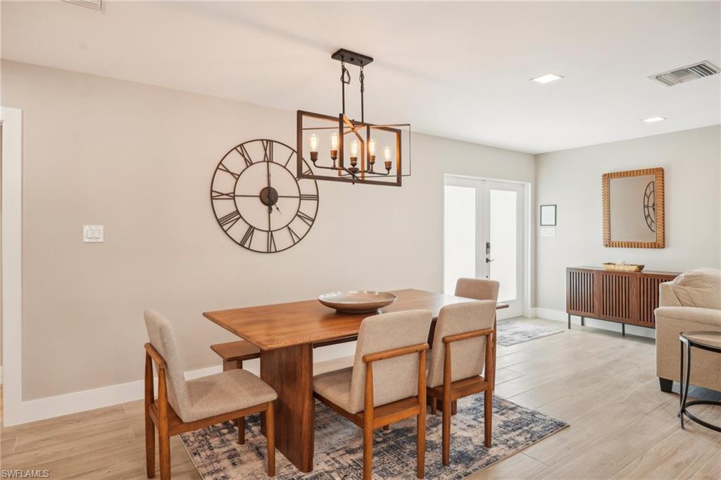 Image 4: Dining room with a notable chandelier and light hardwood / wood-style floors