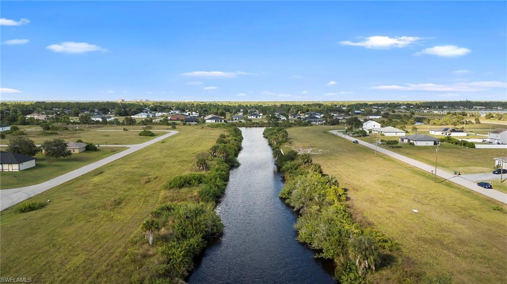 Image 3: Aerial view of residential area featuring a nearby body of water