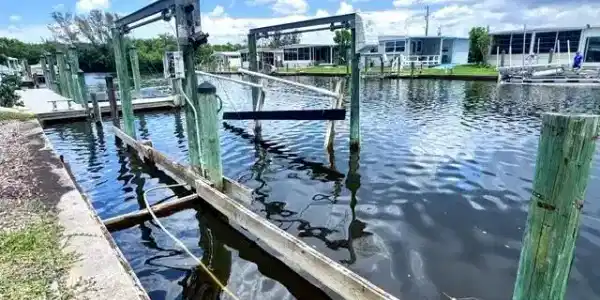 Image 3: Waterfront property featuring a private boat dock with multiple pilings and a boat lift