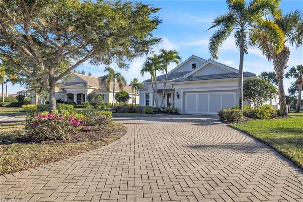 Image 3: View of front of house with decorative driveway, an attached garage, and stucco siding