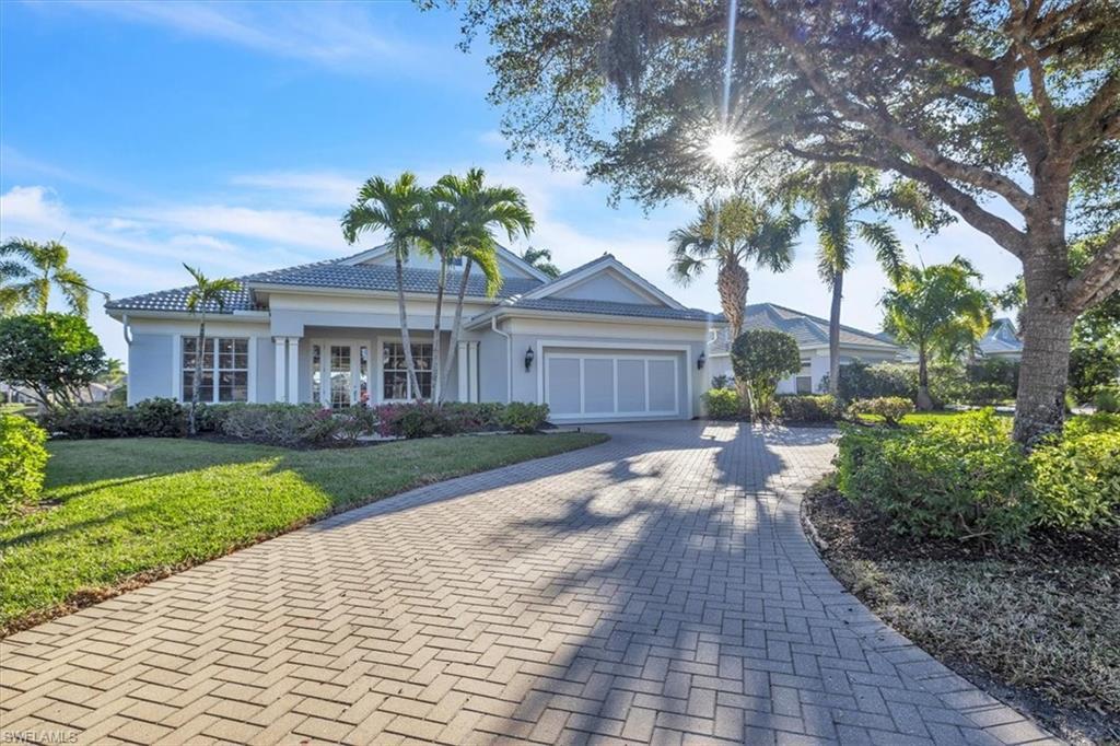 Image 4: Ranch-style house featuring decorative driveway, stucco siding, an attached garage, a front yard, and covered porch