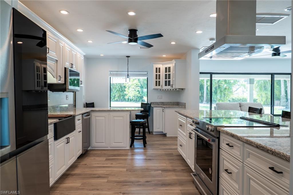 Image 3: Kitchen featuring island exhaust hood, recessed lighting, appliances with stainless steel finishes, and plenty of natural light